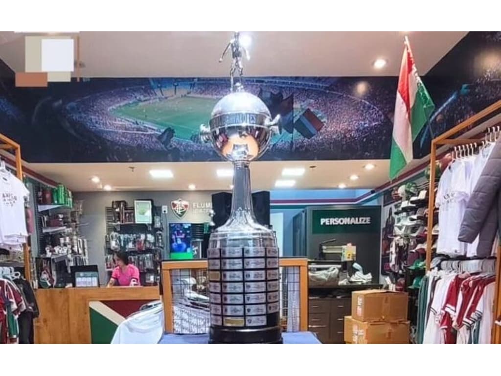 QUANTA INVEJA: Loja do Fluminense expõe réplica da Taça da Libertadores e esconde títulos do Flamengo; entenda