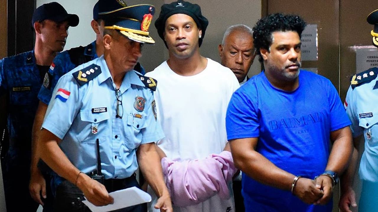 Ronaldinho e Assis deixam a cadeia algemados para nova audiência