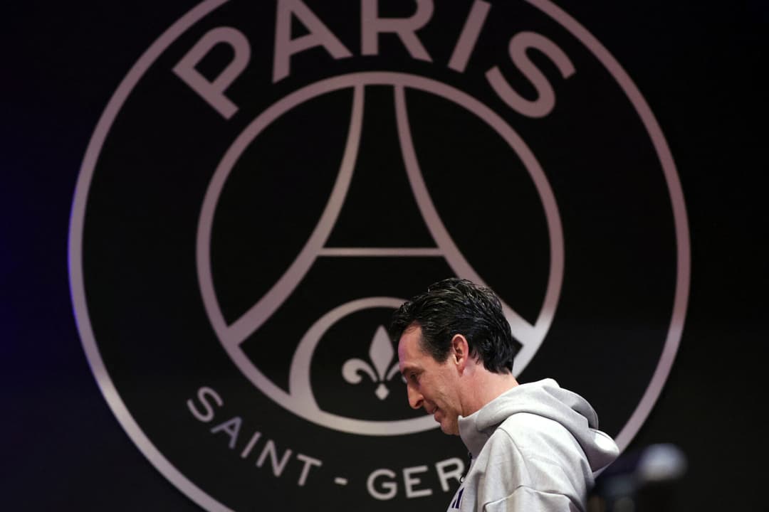 Unai Emery com o escudo do PSG ao fundo na véspera do jogo de Champions League