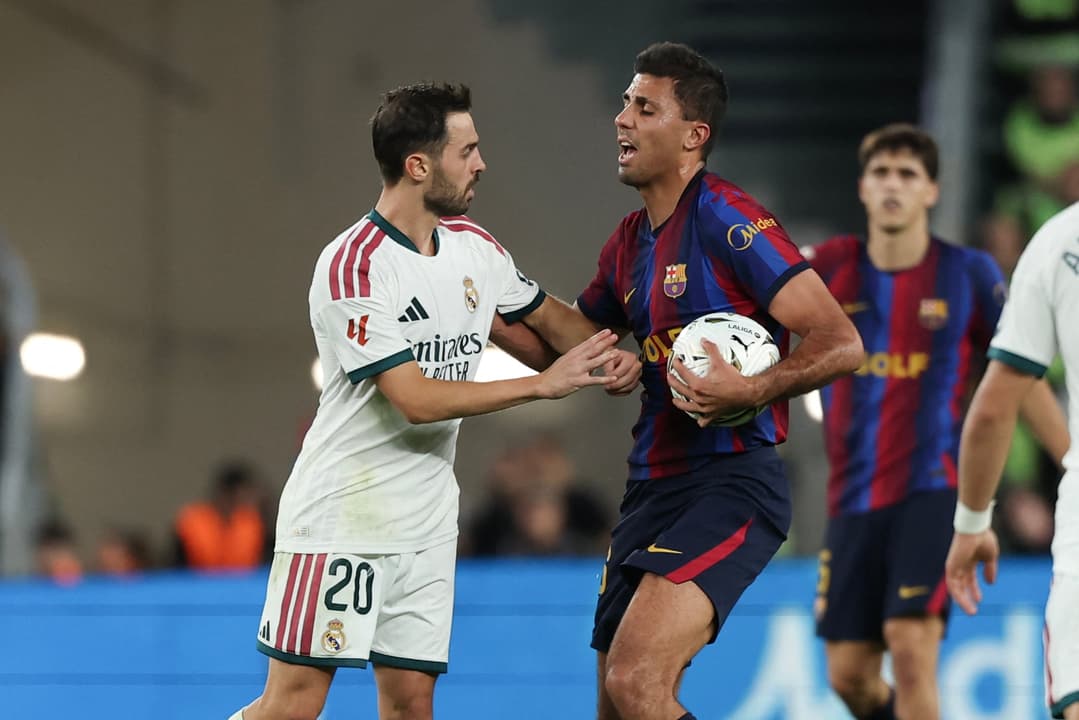 Jogadores do Real Madrid e do Barcelona disputam a bola durante a partida.