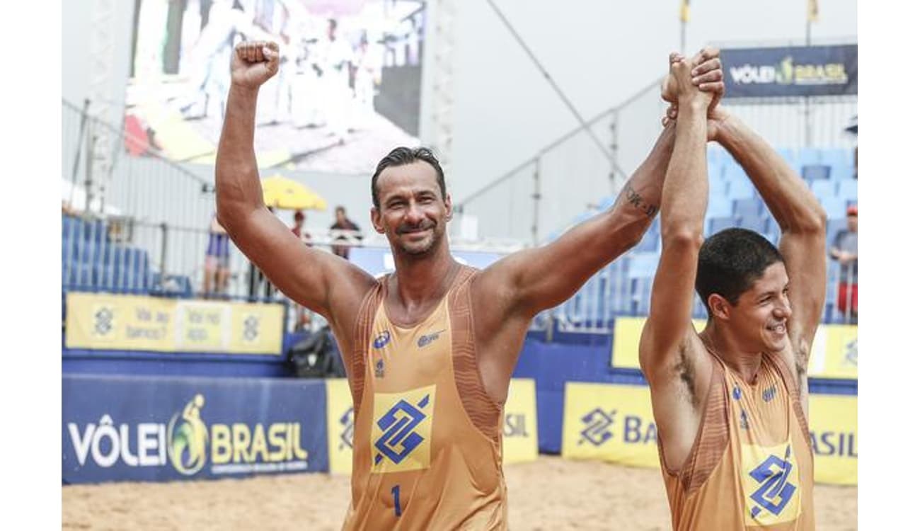 Grupo de amigos felizes jogando vôlei de praia na praia