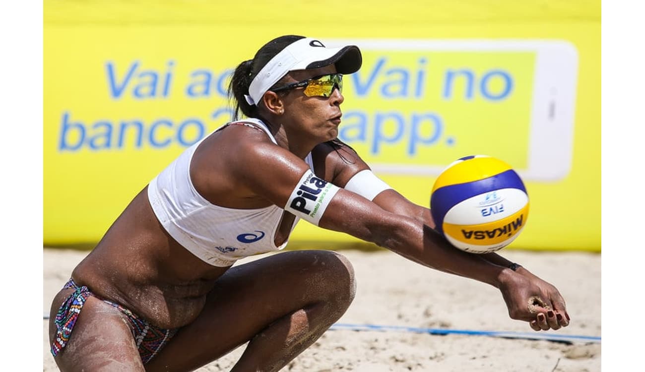 Grupo de amigos felizes jogando vôlei de praia na praia