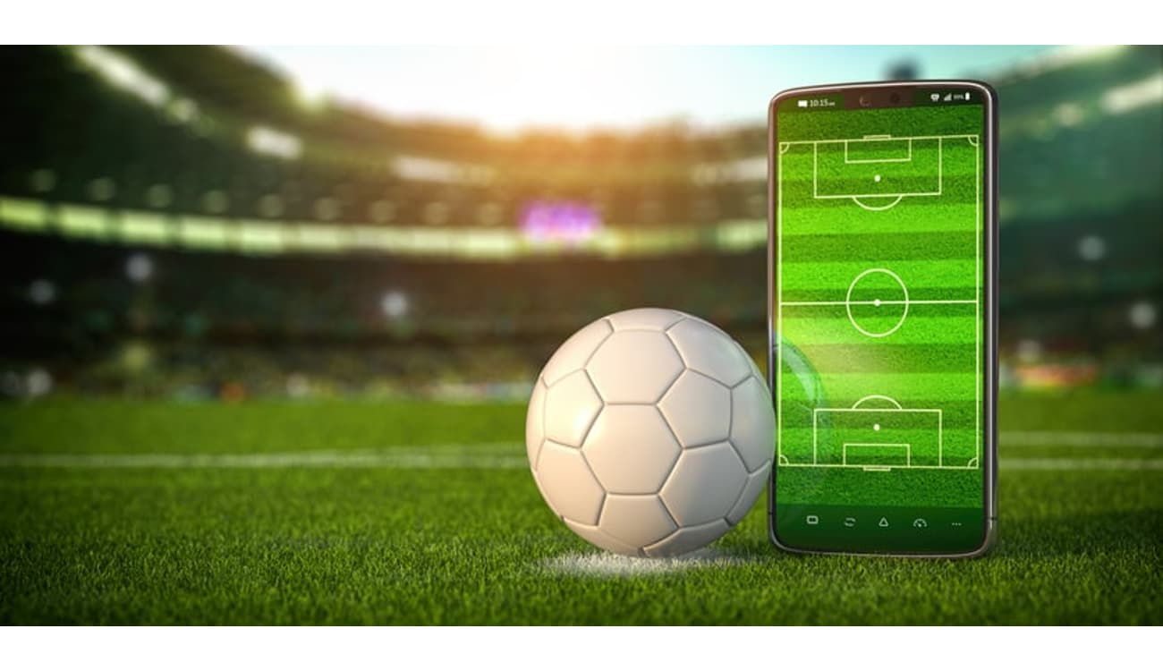 Uma bola de futebol e um smartphone um aplicativo de apostas para anunciar  jogos de futebol e casa de apostas