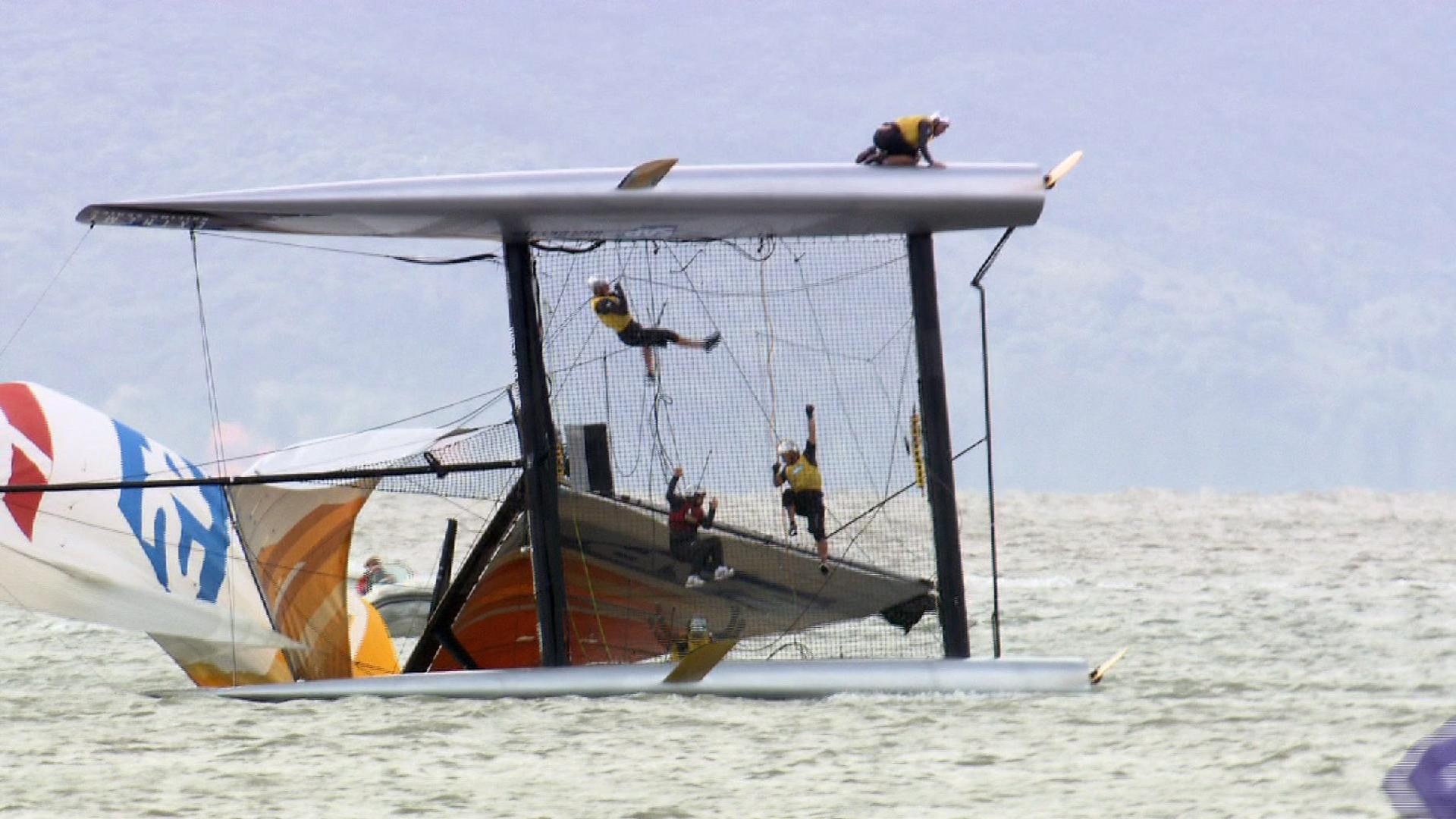 Velejadores do SAP Extreme Sailing Team ficam pendurados após capotagem em Florianópolis (Foto: Vincent Curutchet/Lloyd images)