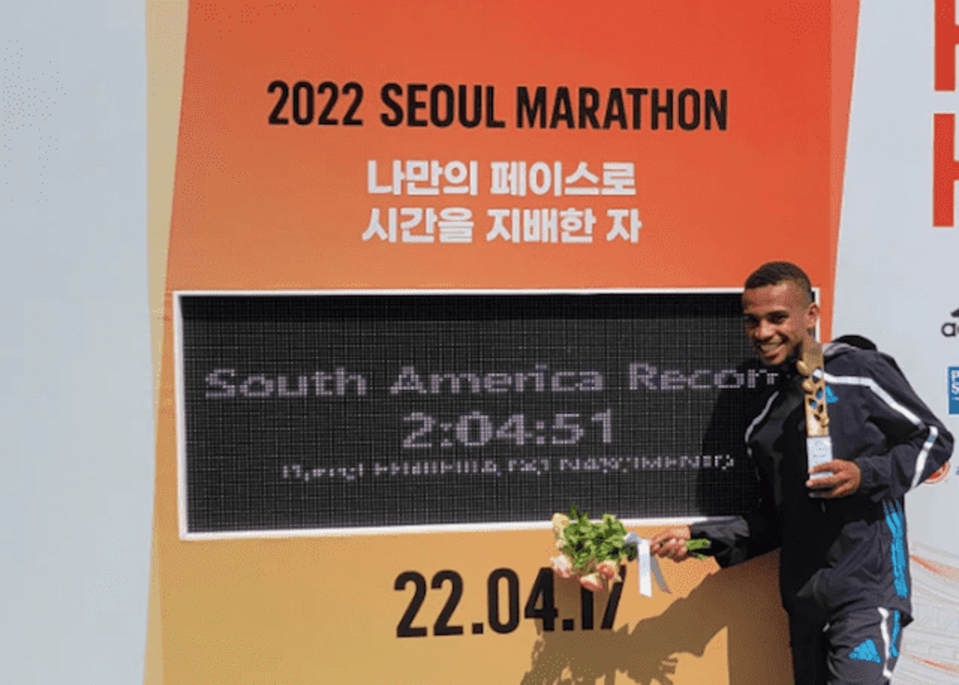 Daniel Nascimento com o novo recorde sul-americano de maratona estampado no placar da Maratona de Seul. (Arquivo pessoal)