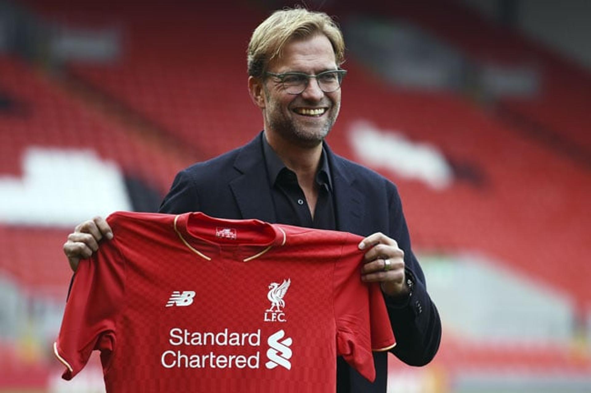 Jürgen Klopp posa com a camisa do Liverpool no Anfield Road (Foto: Paul Ellis / AFP)