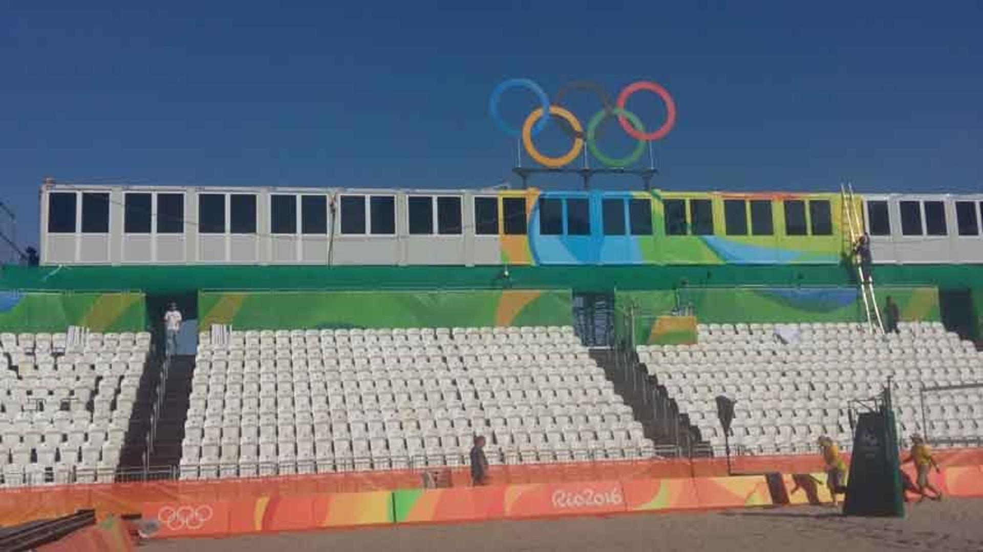 Veja como estava a Arena do vôlei de praia na sexta-feira. Em uma escada, operário trabalha na decoração&nbsp;