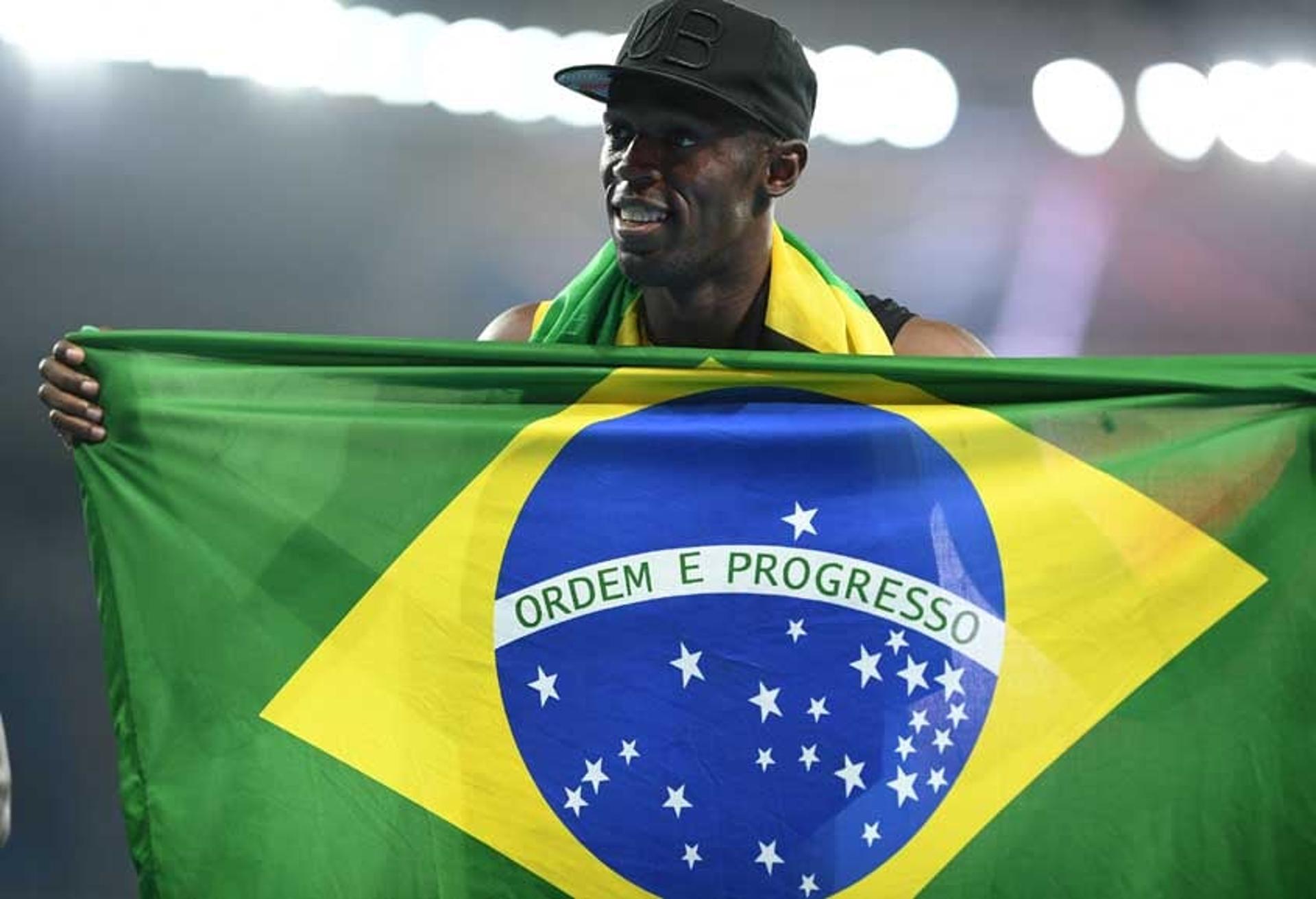 Na comemoração pelo inédito feito na Rio-2016, Usain Bolt exibe uma bandeira do Brasil