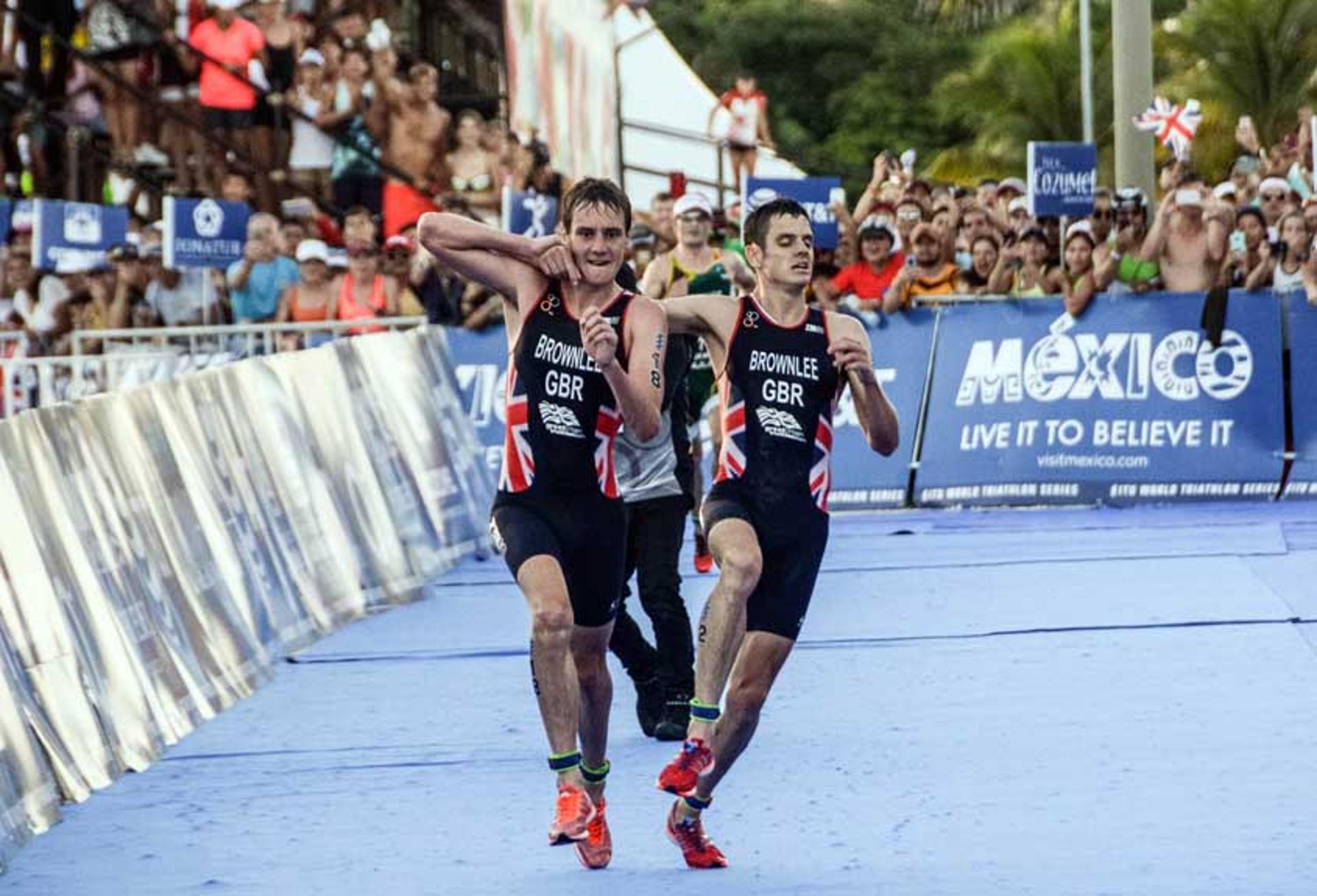 Atleta britânico Alistair Brownlee ajuda seu irmão Jonathan Brownlee antes de cruzar a linha na ITU World Championships Triathlon no Mexico