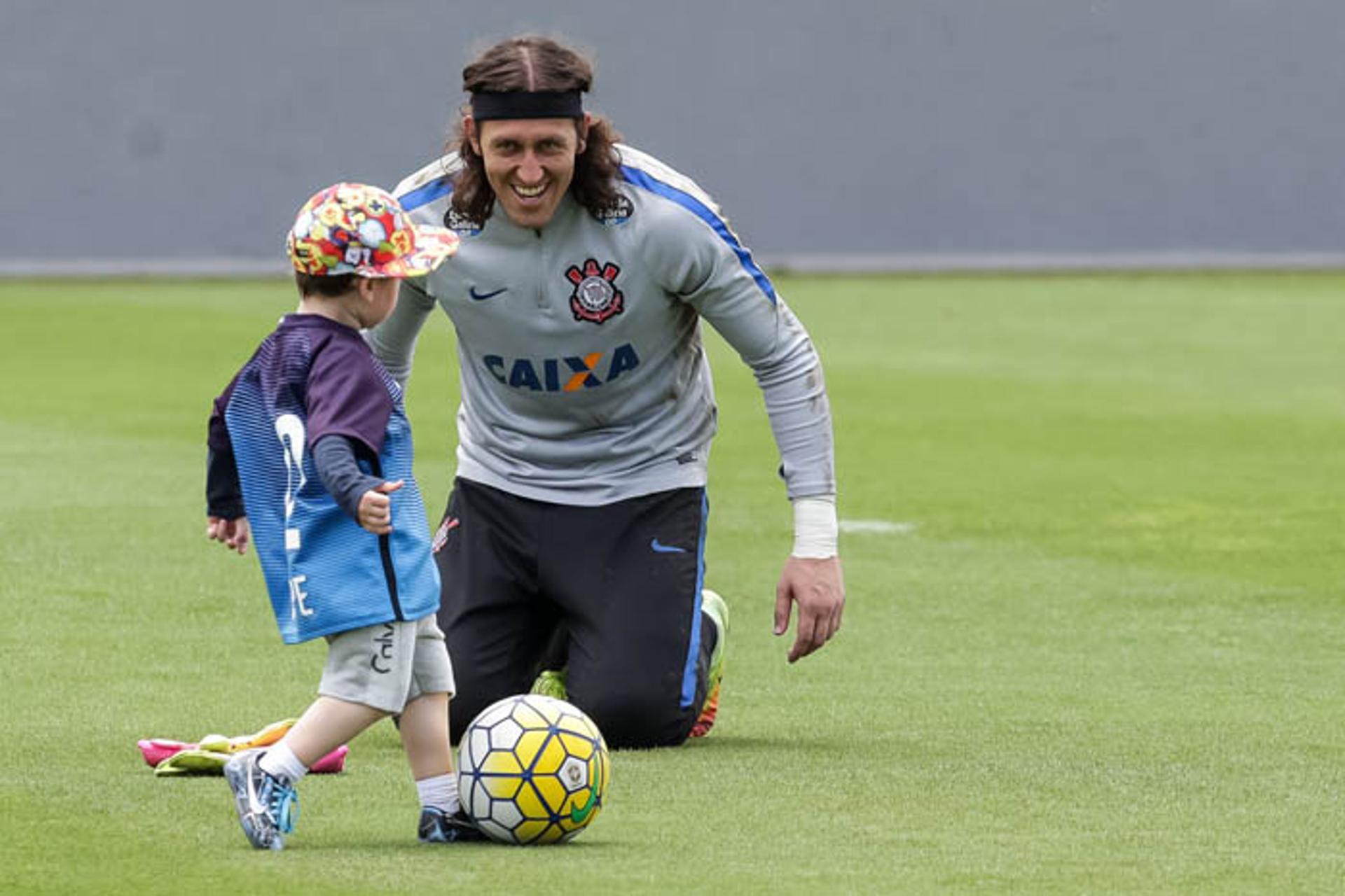 Cássio se divertindo com garoto no gramado do CT