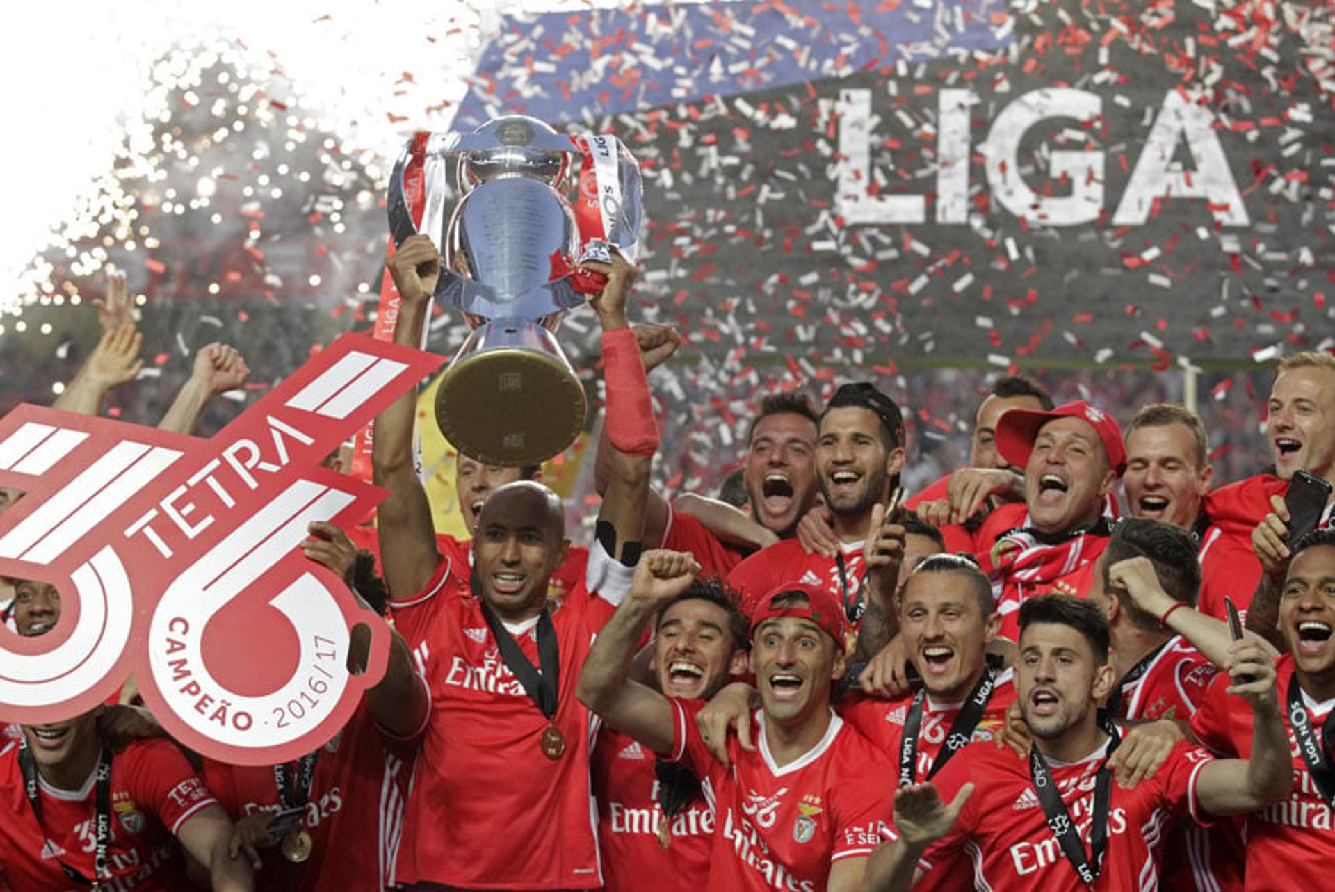 O fim de semana consagrou o Benfica como campeão português. O zagueiro e capitão Luisão ergue a taça