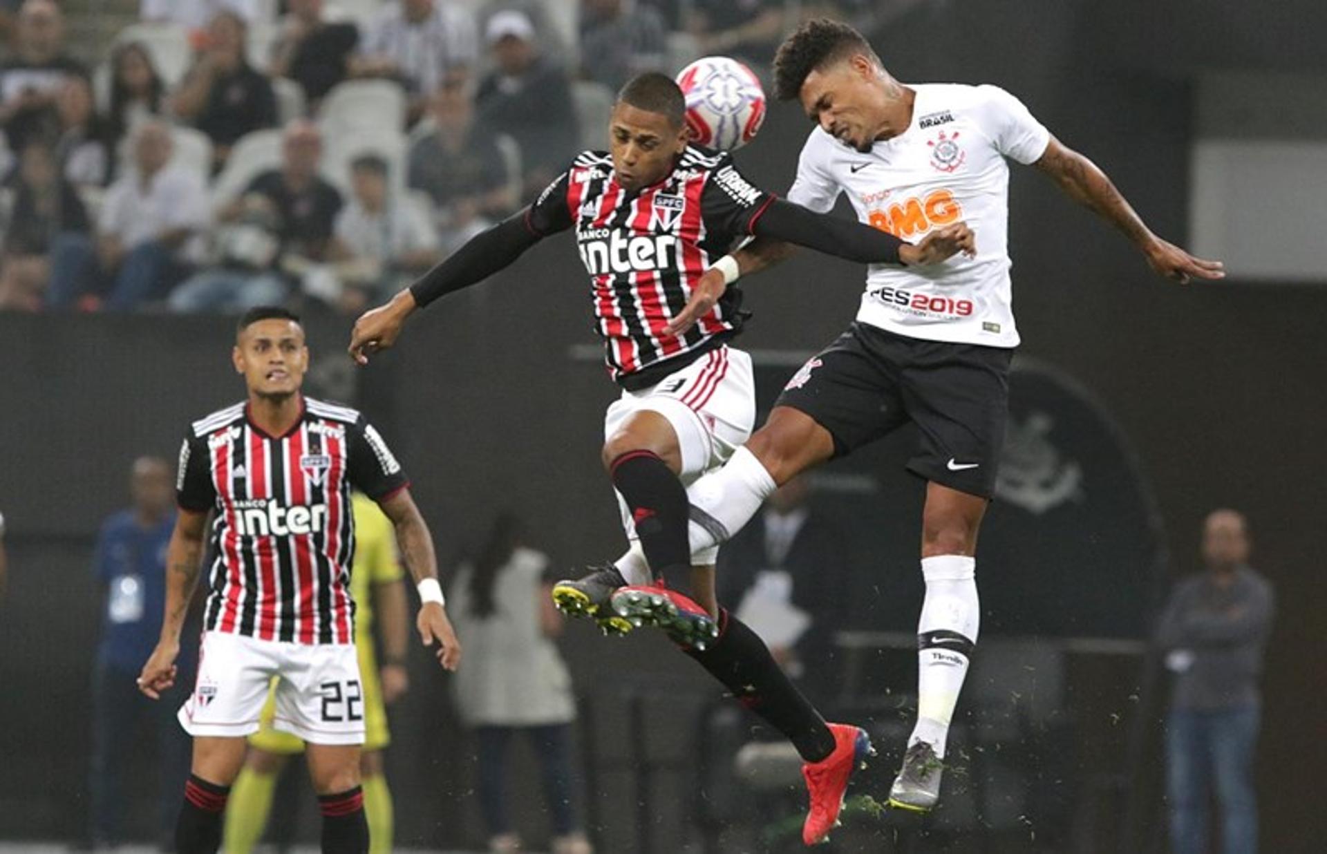 Everton, ao fundo, observa disputa de bola entre o zagueiro Bruno Alves e o volante Júnior Urso, do Corinthians