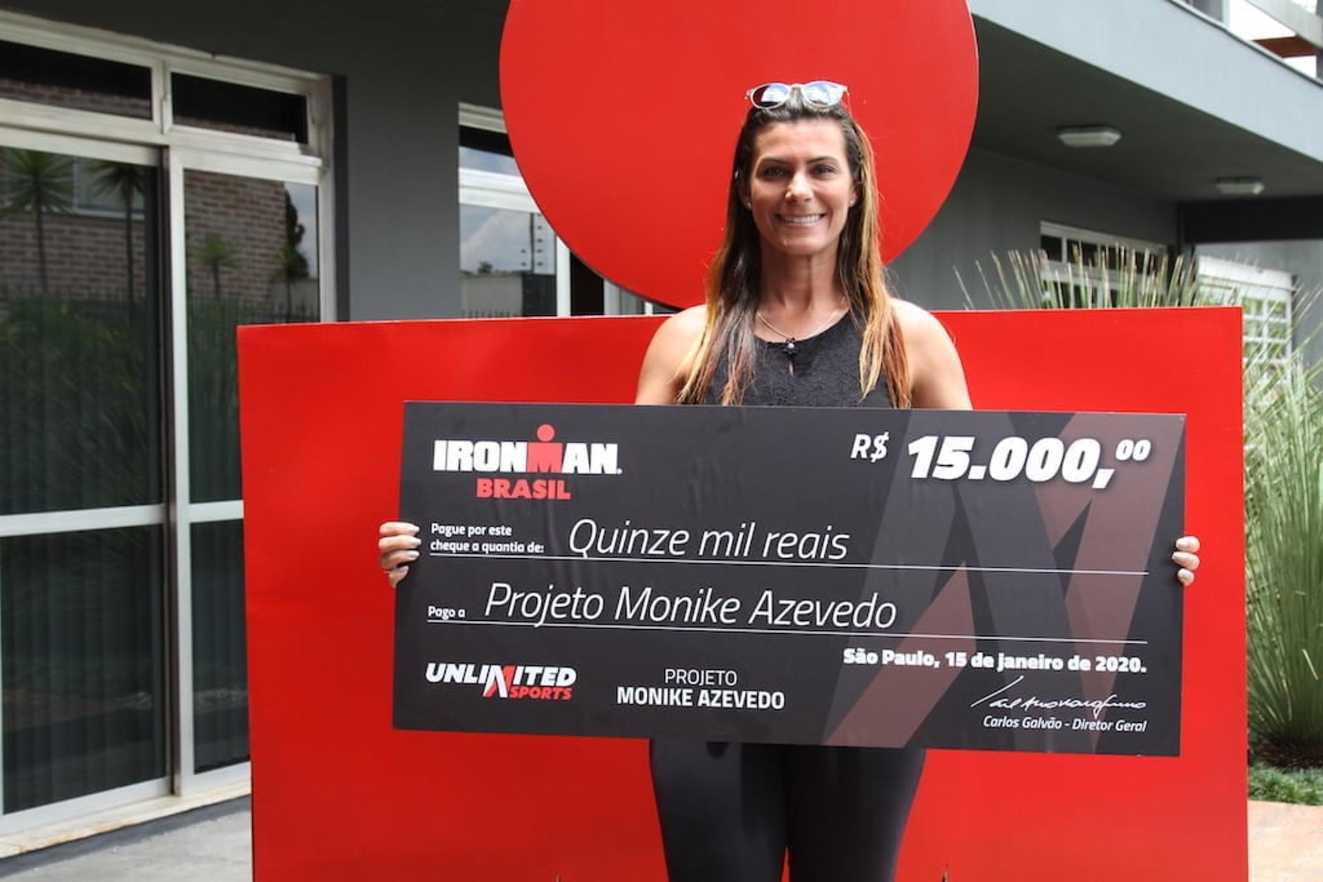 Monike Azevedo com o cheque da doação do Bazar Solidário Ironman Brasil. (Divulgação)