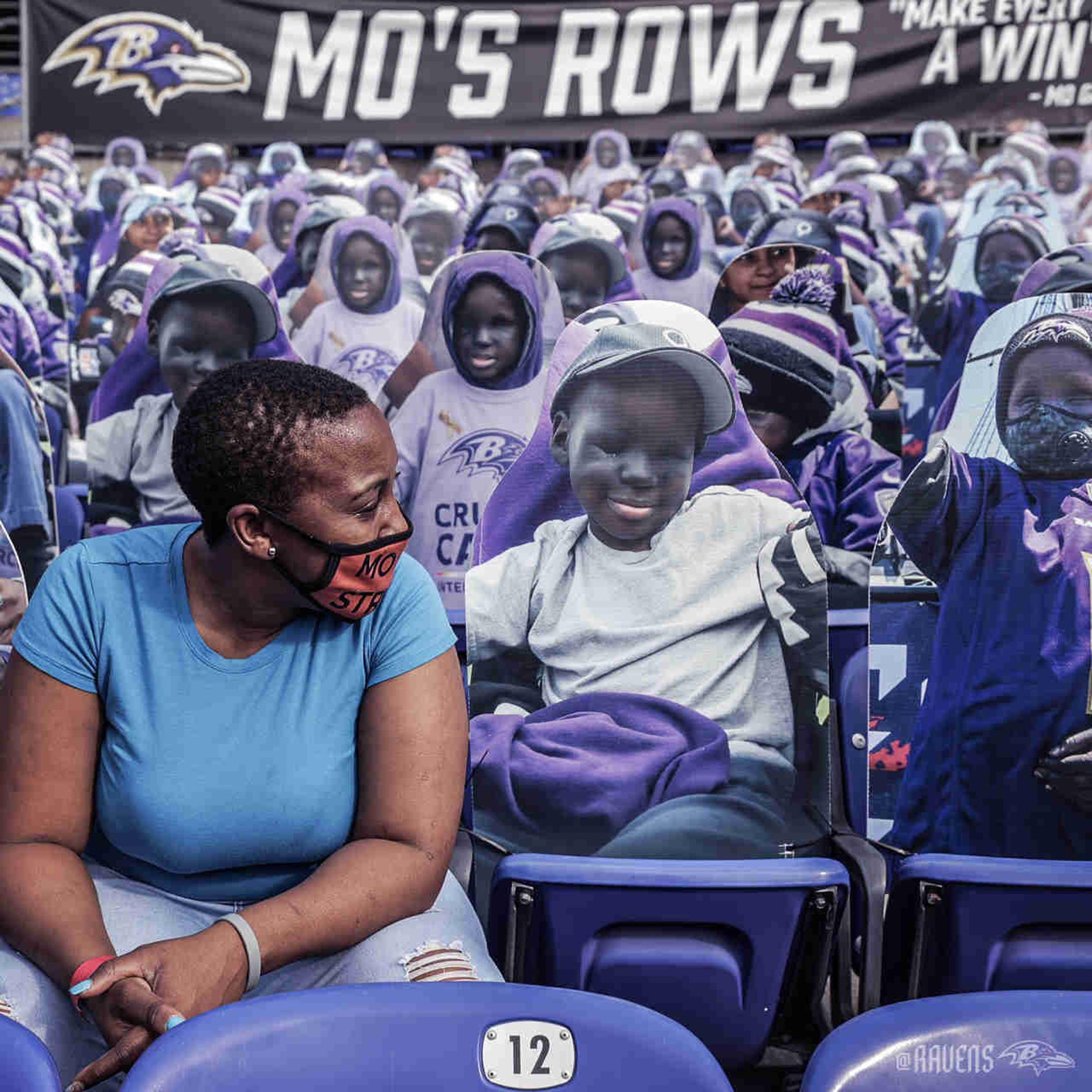 Mãe de Mo Gaba posa junto a foto do filho em sessão do estádio do Baltimore Ravens que o homenageia