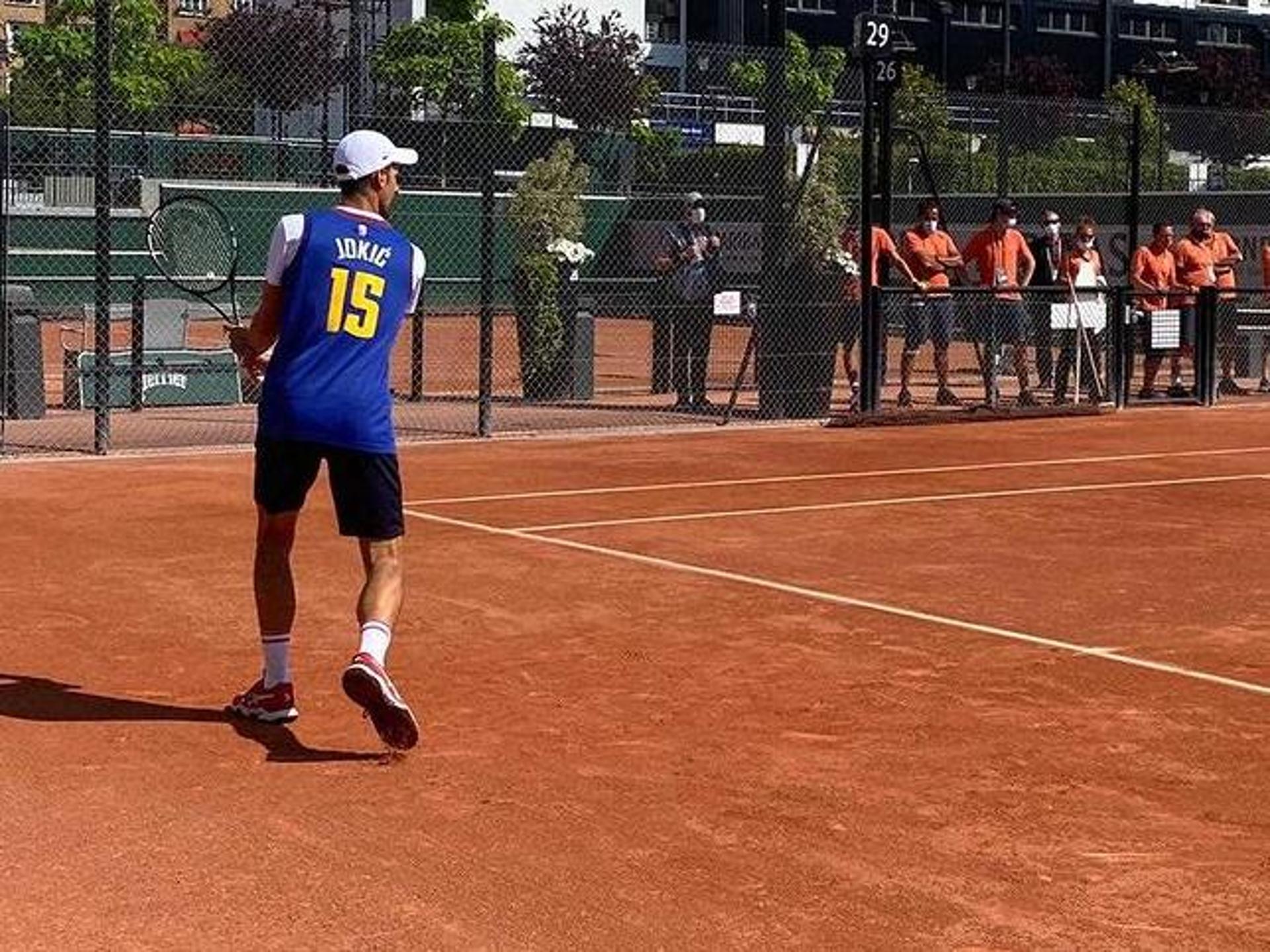 NOvak Djokovic treina em Roland Garros com uniforme de Nikola Jovic