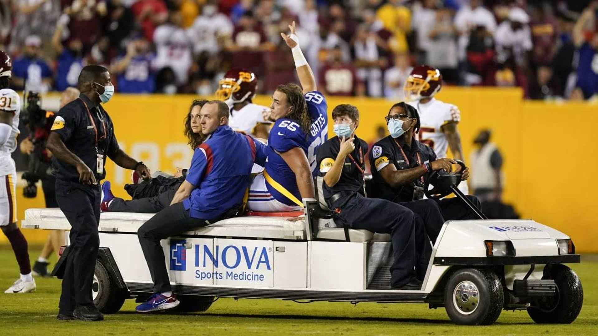 Nick Gates acena positivamente ao deixar o gramado do FedEx Field na maca