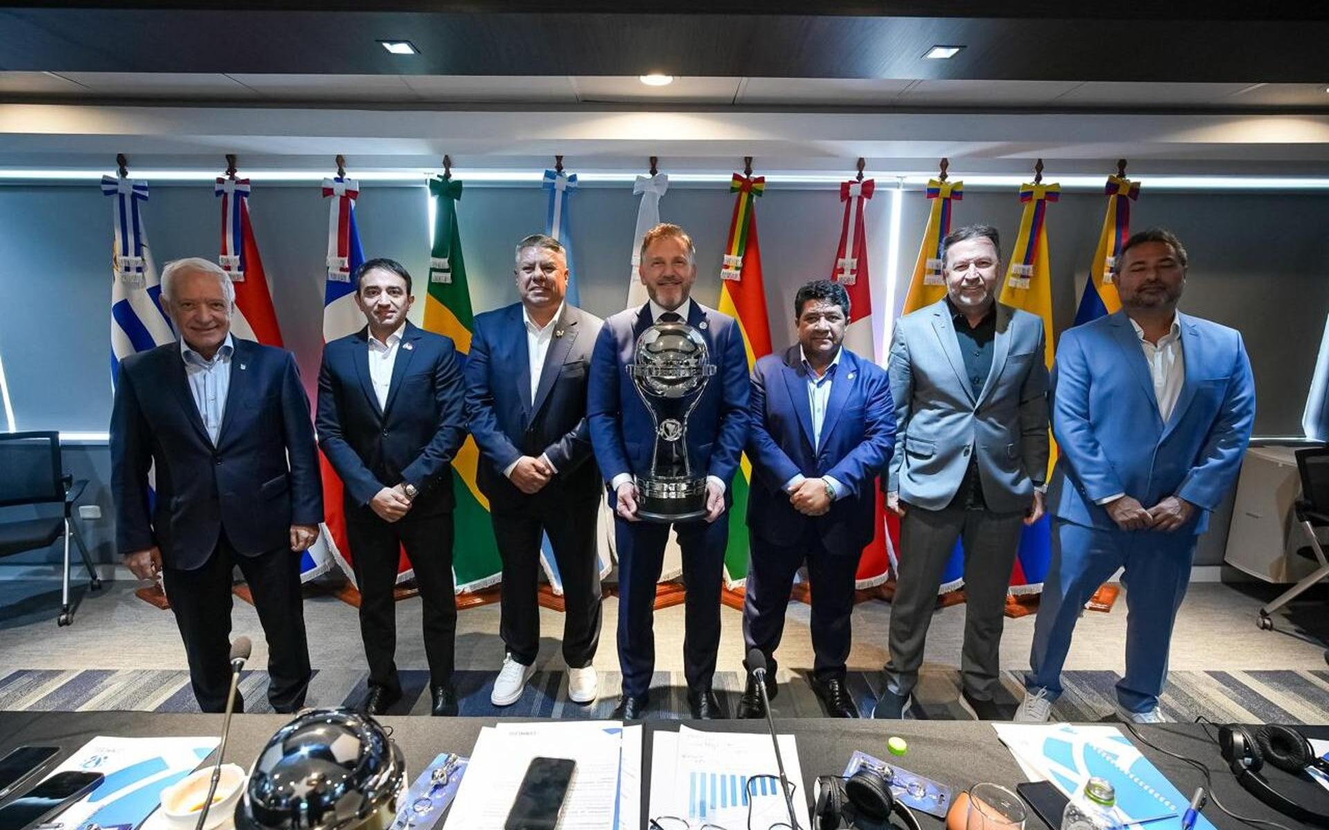 O presidente Alejandro Domínguez, com a taça da Sul-Americana, recebe os colegas da AFA, da CBF e dos clubes semifinalistas (Foto: Reprodução/Conmebol)