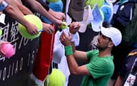 Novak Djokovic autografa bola de fã no Australian Open (Foto: William WEST / AFP)