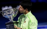 O espanhol Carlos Alcaraz beija seu sétimo Grand Slam, o primeiro no Australian Open (Foto: IZHAR KHAN / AFP)