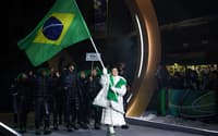 A porta-bandeira do Brasil, Nicole Rocha Silveira (D), desfila com a delegação na cerimônia de abertura dos Jogos Olímpicos de Inverno Milano Cortina 2026, em 6 de fevereiro de 2026. (Foto: Franck Fife/AFP)