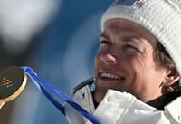 O norueguês Johannes Høsflot Klæbo comemora o ouro no pódio dos 10km livre com largada intervalada do esqui cross-country, nos Jogos Olímpicos de Inverno Milano Cortina 2026, em Tesero, em 13 de fevereiro de 2026. (Foto: Javier Soriano/AFP)