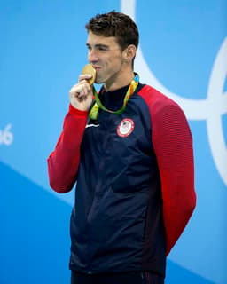 Michel Phelps beija, emocionado, sua medalha de ouros nos 200 m medley, a quarta seguida na prova