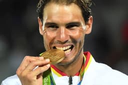 Nadal morde sua medalha de ouro nas duplas, ao lado de Marc Lopez