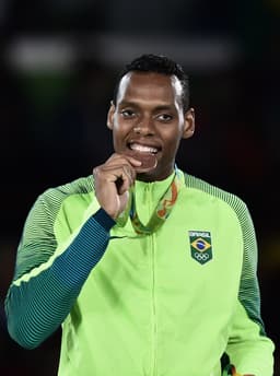 Maicon Siqueira morde a medalha de bronze conquistada<br>