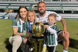 Willian Farias com sua família e a taça do Paranaense