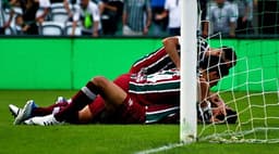 Ganso caído no gramado sendo festejado pelos companheiros de Fluminense