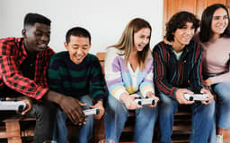 jovens-amigos-multirraciais-se-divertindo-jogando-videogame-em-casa-concentre-se-no-rosto-da-menina-no-centro-scaled-aspect-ratio-512-320