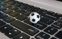 Football ball, soccer ball, on laptop keyboard