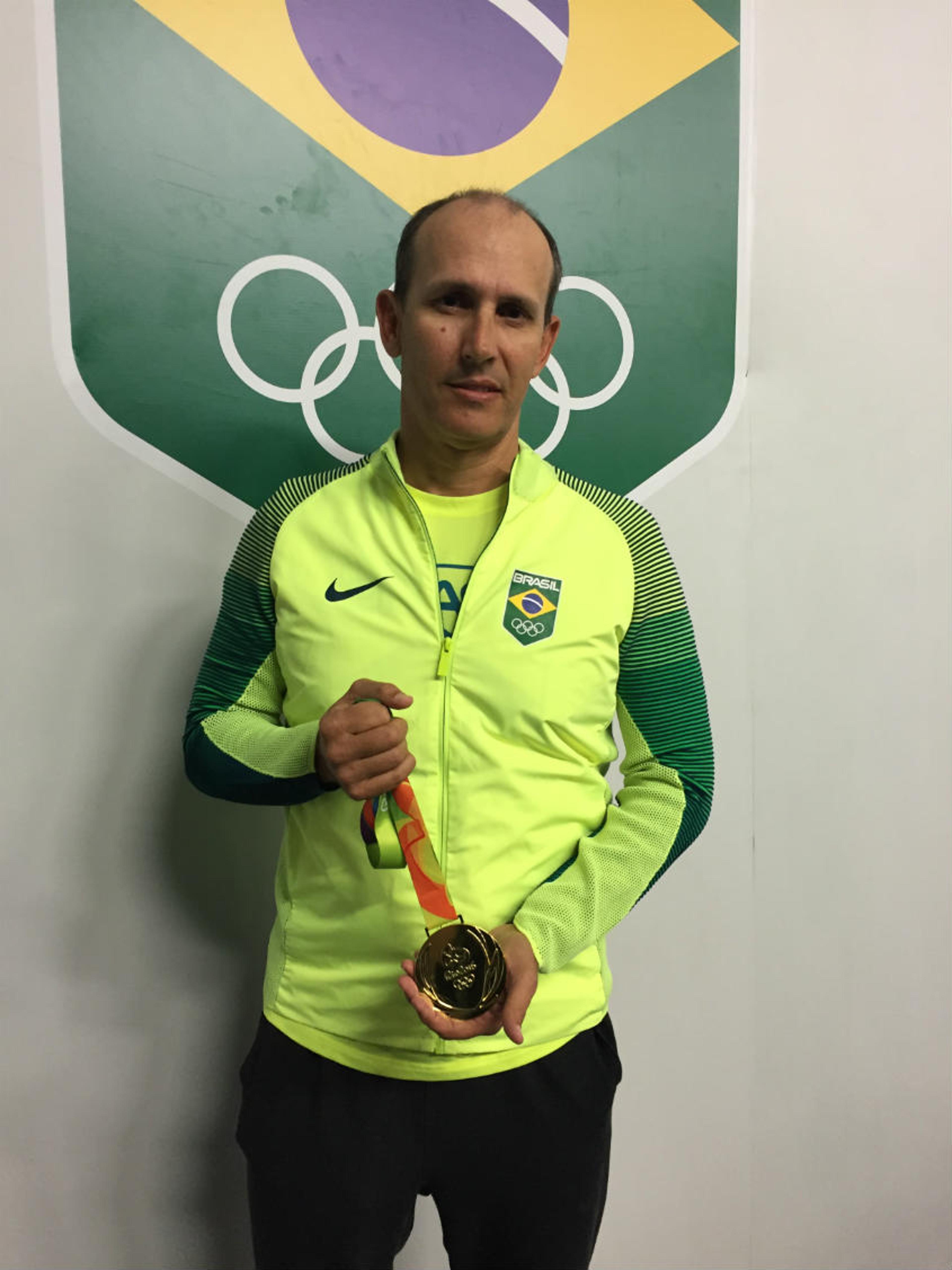 Alison e Bruno homenageiam técnico com réplica de medalha