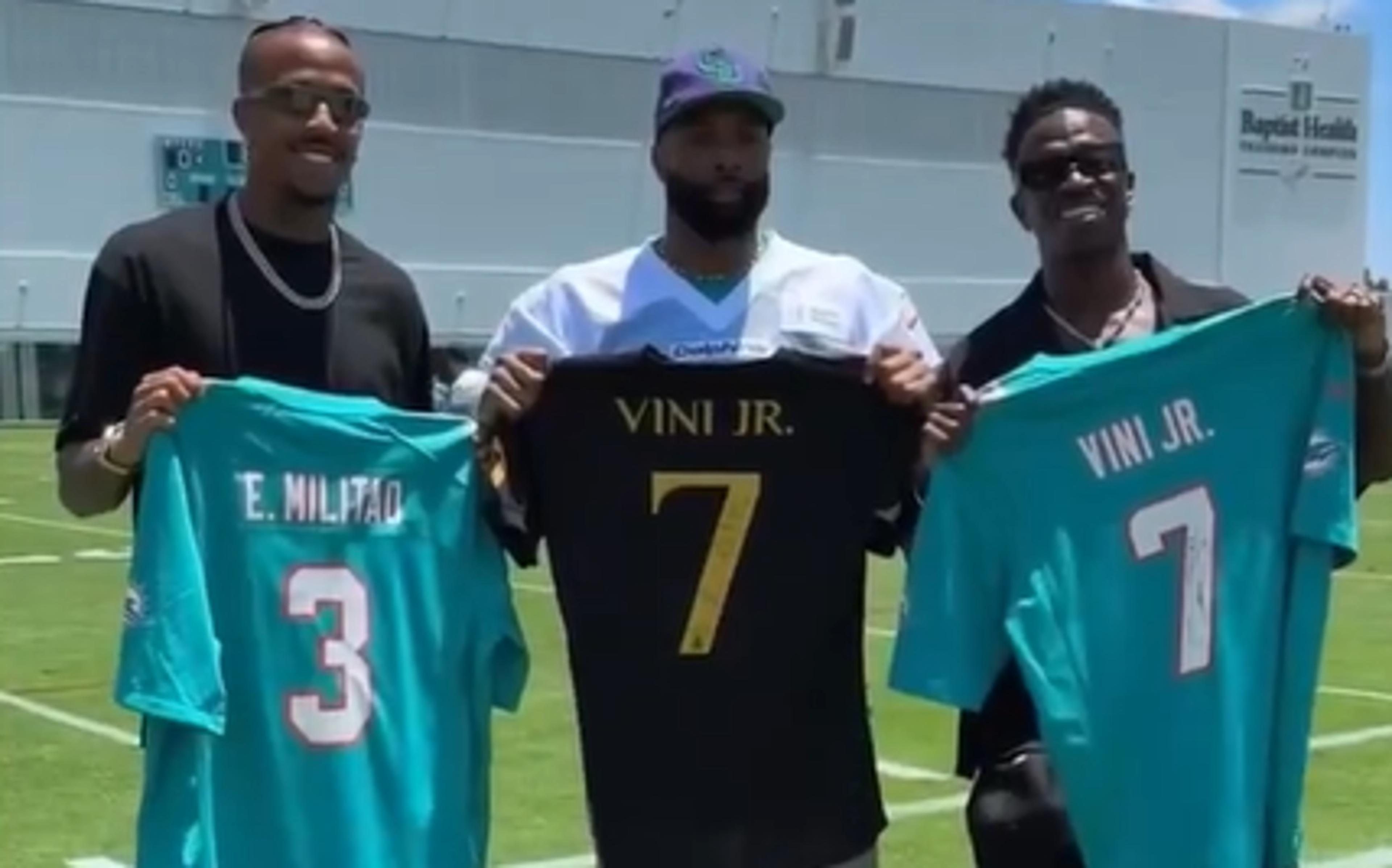 Vini Jr e Militão ganham camisas do Miami Dolphins durante visita a centro de treinamento