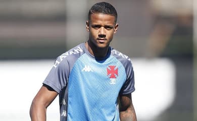 Dois jogadores de futebol jogando futebol no campo marcando um