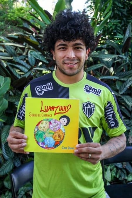 Luan posa com o livro infantil baseado em sua infância (Foto: Diulgação/Atlético-MG)