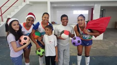 Atletas do Nestlé posam com crianças em ação social
