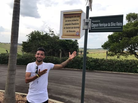 Clayson posa ao lado da rotatória com seu nome