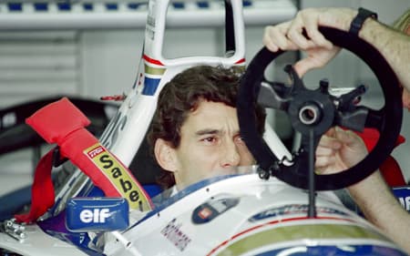 Brazilian F1 driver Ayrton Senna inspects and adjusts the steering wheel in the pits on May 1, 1994 before the start of the San Marino Grand Prix in Imola. Senna died after crashing in the seventh lap. AFP PHOTO JEAN-LOUP GAUTREAU