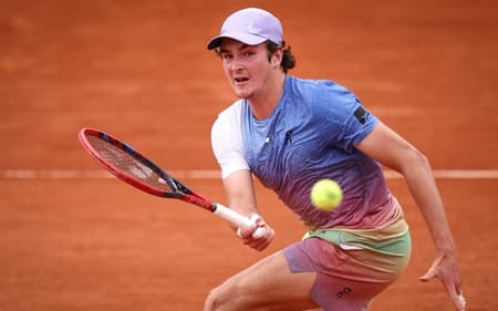 João Fonseca faz um voleio na partida contra o francês Pierre-Hugues Herbert em Roland Garros (Photo by Anne-Christine POUJOULAT / AFP)