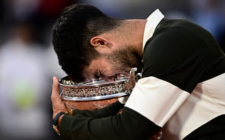 O espanhol Carlos Alcaraz segura o troféu de Roland Garros (Foto: JULIEN DE ROSA / AFP)