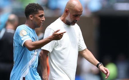 Pep Guardiola conversa com Rico Lewis, expulso posteriormente, durante o intervalo (Foto: Charly Triballeu/AFP)