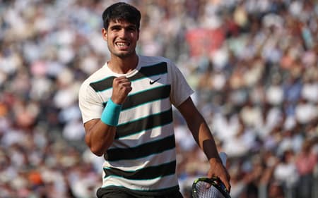 O espanhol Carlos Alcaraz reage contra o espanhol Jaume Munar durante a partida de tênis das oitavas de final do torneio de simples masculino do Campeonato de Tênis HSBC ATP, no Queen's Club, no oeste de Londres, em 19 de junho de 2025. (Foto de HENRY NICHOLLS / AFP)