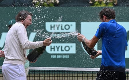O cazaque Alexander Bublik (e) e o russo Daniil Medvedev celebram com champanhe após a final do ATP de Halle (Foto: CARMEN JASPERSEN / AFP)