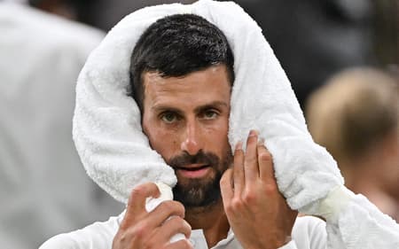 O sérvio Novak Djokovic usa uma toalha na vitória sobre o francês Alexandre Muller em Wimbledon (Foto: Glyn KIRK / AFP)