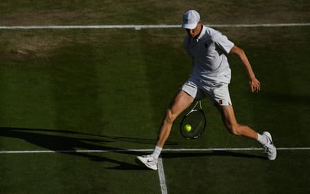 Sinner devolve a bola entre as pernas na final contra Alcaraz (Foto: Glyn KIRK / AFP)