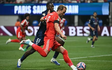 Harry Kane e Pacho disputam a bola em PSG x Bayern (Foto: Paul ELLIS / AFP)