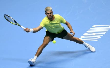 O espanhol Carlos Alcaraz devolve a bola na vitória sobre o australiano Alex De Minaur (Foto: Marco BERTORELLO / AFP)