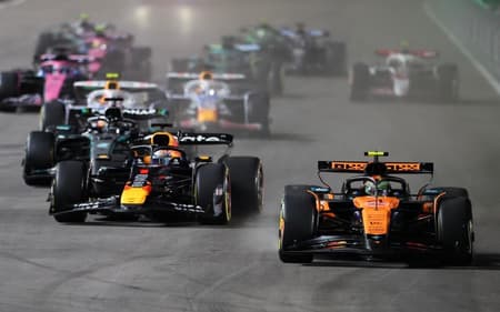 Lando Norris (d) é ultrapassado por Max Verstappen logo após a largada do GP de Las Vegas (Foto: Patrick T. Fallon / AFP)