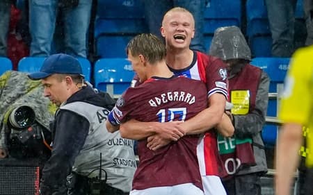 Haaland e Odegaard se abraçam na comemoração do gol da Noruega sobre a Itália, pelas Eliminatórias para a Copa do Mundo
